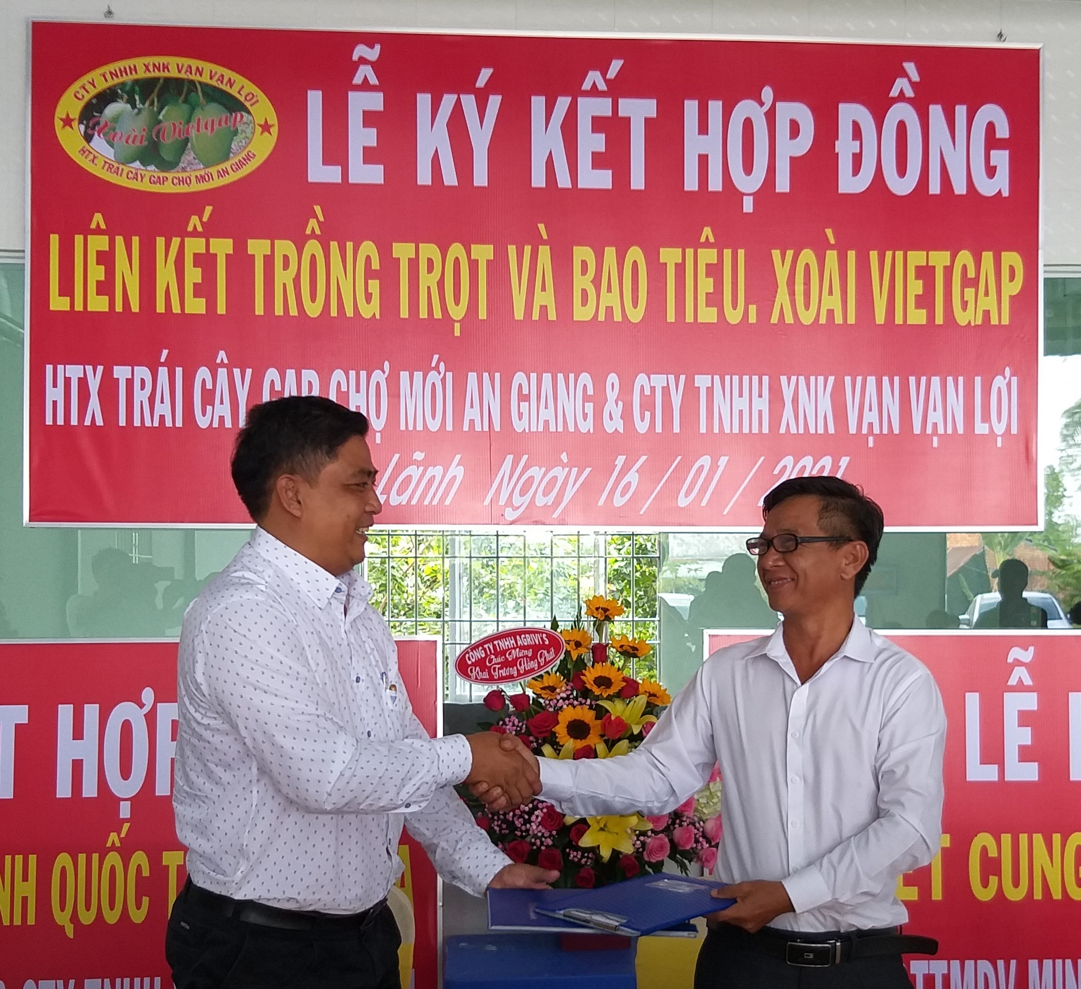Ô. Trần Khánh Dư, GĐ HTX trái cây GAP Chợ Mới (bên trái) ký hợp đồng với Ô. Phan Thanh Bút (Chủ tịch HĐQT công ty XNK trái cây Vạn Vạn Lợi (bên phải)